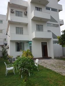 a building with two white chairs in front of it at Anne's Airport Transit Villa & Hotel in Katunayake