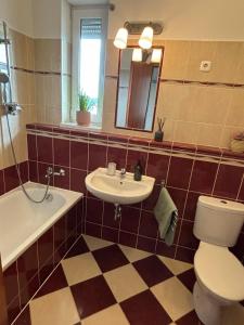 a bathroom with a toilet and a sink and a tub at Club218 Holiday Apartman Siófok in Siófok