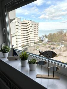 a window sill with potted plants and a view of the ocean at Club218 Holiday Apartman Siófok in Siófok