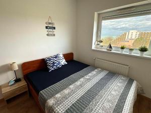 a small bedroom with a bed and a window at Club218 Holiday Apartman Siófok in Siófok