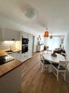 a kitchen and living room with a table and chairs at Club218 Holiday Apartman Siófok in Siófok