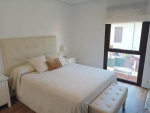 a bedroom with a large bed and a window at Agradable adosado en soto de llanera in Llanera