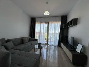 - un salon avec un canapé et une télévision dans l'établissement Mulaj Hotel, à Tirana