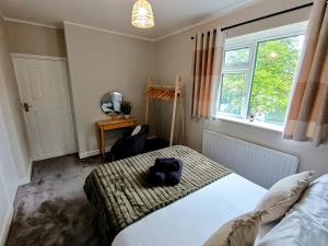 a bedroom with a bed and a chair and a window at The Tansley Gardens in Darlington