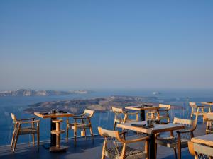 - un restaurant avec des tables et des chaises offrant une vue dans l'établissement Stella Rocca A Mare, à Imerovigli