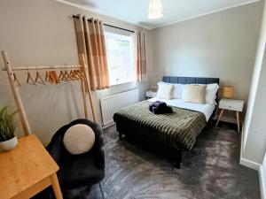 a small bedroom with a bed and a chair at The Tansley Gardens in Darlington