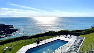 uma vista para o oceano a partir de uma casa com piscina em Watersmeet Hotel em Woolacombe