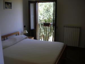 a bedroom with a bed and a window with a balcony at Agriturismo Torre Rinusa in Pietrapaola +50 photos