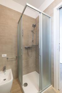 a shower with a glass door next to a sink at Al Mare da Lù in Riccione