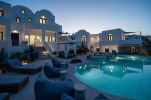a villa with a swimming pool at night at CUORE SANTO SUITES in Fira