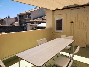 a white table and chairs on a balcony at Triplex avec terrasse en rooftop, au coeur de Sete in Sète