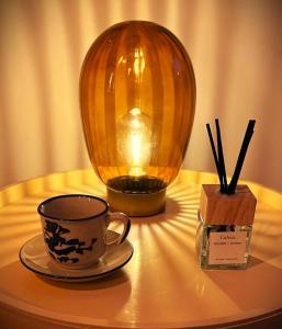 un tavolo con una tazza, una candela e un vaso di SerrART 325 a Ivrea