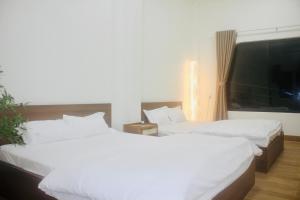 Cu Lao ThuにあるSeahorse Homestay & Villa - Đảo Phú Quýの窓付きの客室で、白いベッド2台が備わります。