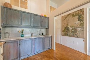 una cocina con armarios azules y una pintura en la pared en Sardinia Home Design, en Cagliari 50 fotos más