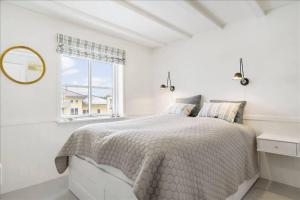 a white bedroom with a bed and a window at Holiday Apartment With Ocean View in Hals