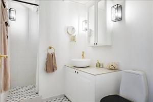La salle de bains blanche est pourvue d'un lavabo et de toilettes. dans l'établissement Holiday Apartment With Ocean View, à Hals