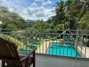einen Balkon mit Blick auf den Pool und die Palmen in der Unterkunft Heavens Holiday Resort in Kandy