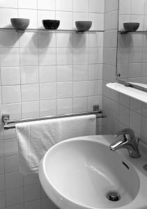 bagno con lavandino, specchio e asciugamani di SerrART 325 a Ivrea