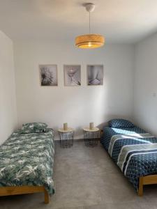 1 dormitorio con 2 camas y 2 mesas. en Maison neuve, jardin et accès privé à la plage, en Canet-de-Salars