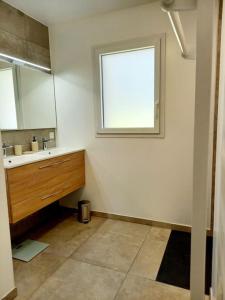 a bathroom with a sink and a window at Maison neuve, jardin et accès privé à la plage in Canet-de-Salars