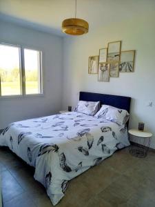 a bedroom with a large bed with a blue headboard at Maison neuve, jardin et accès privé à la plage in Canet-de-Salars