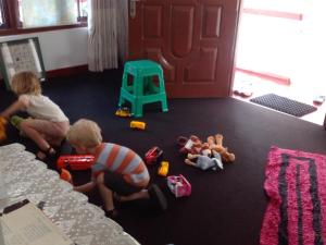 zwei Kinder spielen mit Spielzeug auf dem Boden in einem Zimmer in der Unterkunft Hanthana Jungle View Holiday Home in Kandy