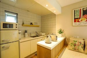 a small kitchen with a refrigerator and a sink at Haengok Guesthouse in Jeonju