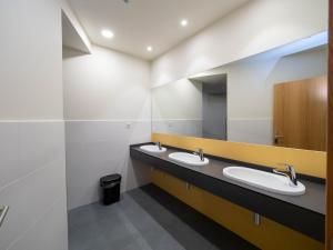 a bathroom with two sinks and a mirror at LUMEN ALBERGUE in Mondoñedo