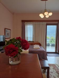 a room with a table with a vase of red roses at LOUNA in Metsovo