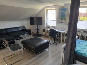 a living room with a couch and a bed and a desk at Eiland-Apartment in Springe