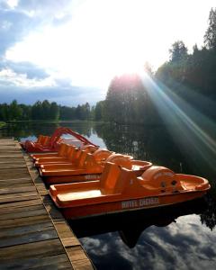 una fila de barcos naranjas estacionados junto a un muelle en Domek letniskowy w Kamionce en Kamionka