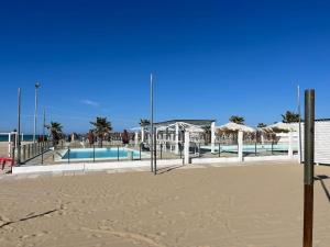 einen Strand mit Pool und Sonnenschirmen am Strand in der Unterkunft Promo Black Friday Residenza Esclusiva 2 Suite, 2 Bagni, Balcone con Vista e Area Fitness in Pescara