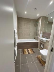 a bathroom with a tub and a toilet and a sink at Upper executive apartment in Dagenham +10 photos