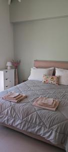Una cama con dos toallas encima. en Melissafarm Guest House, en Palaia Epidavros