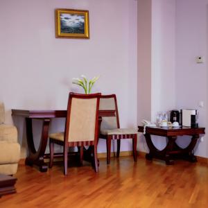 a dining room with a table and two chairs and a table with a plant at Latar Hotel Yerevan in Yerevan