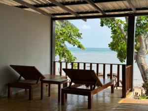 een tafel en stoelen op een balkon met uitzicht op de oceaan bij Libong Loft Home in Ko Libong