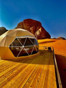 a tent on a wooden deck in the desert at Shaheen Camp Wadi rum in Wadi Rum