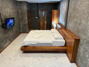 1 dormitorio con 1 cama y TV. en Libong Loft Home, en Ko Libong