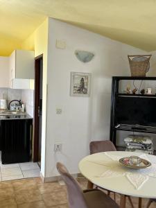 a living room with a table and a kitchen at Apartmani Fijan in Pag