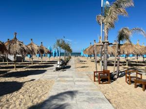 una spiaggia sabbiosa con ombrelloni di paglia e l'oceano di 3 SUITES Padronali 300m DAL MARE a Pescara