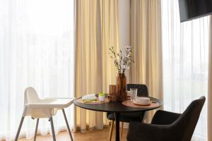 a dining room table with chairs and a vase with flowers at Bronze Colour Studio in Tartu City Centre in Tartu +15 photos