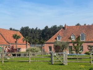 a farm with a fence and houses in the background at B&B DeSo in Zonnebeke