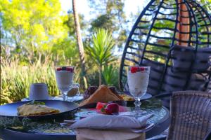 een tafel met een bord eten en glazen water bij Quaint Cottage in Graskop