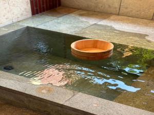 a wooden bowl sitting on top of a pool of water at 風まち in Yawatano