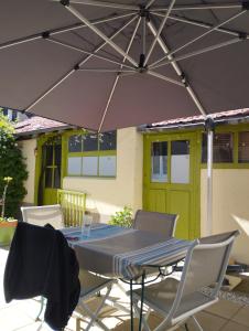 stół i krzesła pod parasolem na patio w obiekcie Chambre agréable au fond du jardin w mieście Sancoins