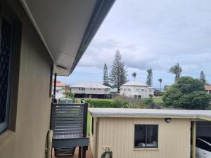 a porch with a chair and a house at See Street Apartments by Kacys in Bargara +1 photo