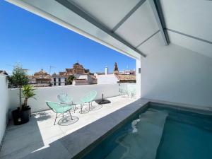 einen Balkon mit Stühlen und einem Pool in der Unterkunft Apartamentos Los Patios de la Judería in Córdoba