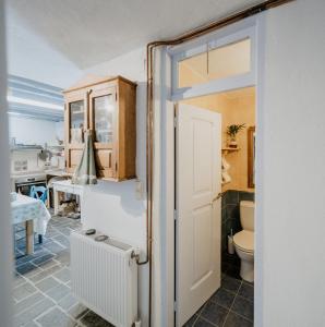 a bathroom with a white door and a toilet at Artistic Home- 250yr old traditional village house in Koskinou