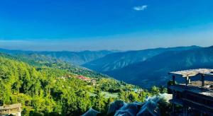 uma vista para um vale com árvores e montanhas em Hotel Radian regency - Family Vacations - Tasty Food - Parking Space and Top Rated Property in KUFRI em Shimla