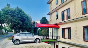 um carro prateado estacionado em frente a um edifício em Hotel Radian regency - Family Vacations - Tasty Food - Parking Space and Top Rated Property in KUFRI em Shimla